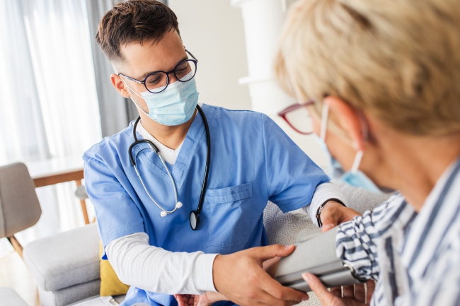 male nurse checking patient blood pressure