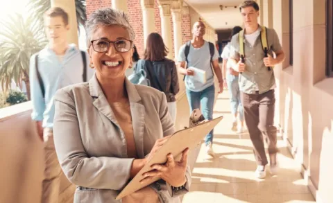 K-12 school administrator with clipboard in outdoor hallway
