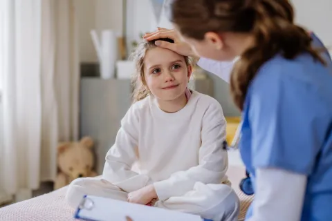 registered nurse and child patient in hospital